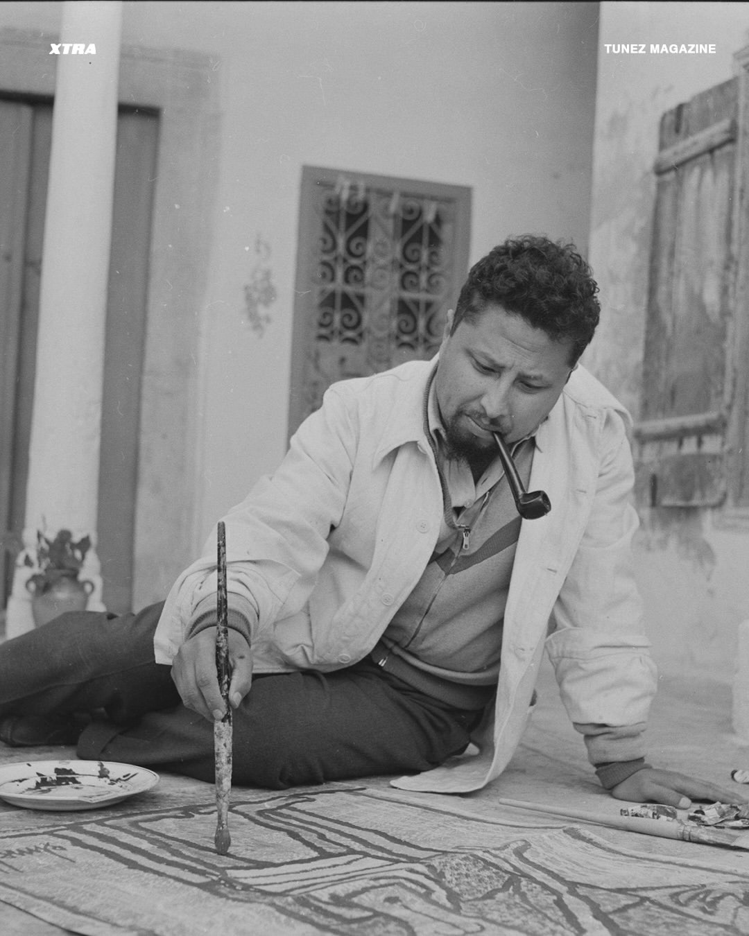 Hatem El Mekki painting on the floor of a Tunisian courtyard